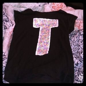 Black/colorful shirt with the letter T on it.